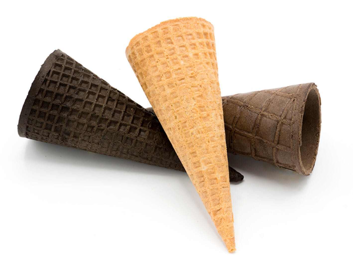 Drei leere Waffeleis-Tüten - eine hellbraune, eine mittelbraune und eine dunkelbraune - sind auf einem weißen Hintergrund angeordnet, wobei sich die Tüten überlappen.