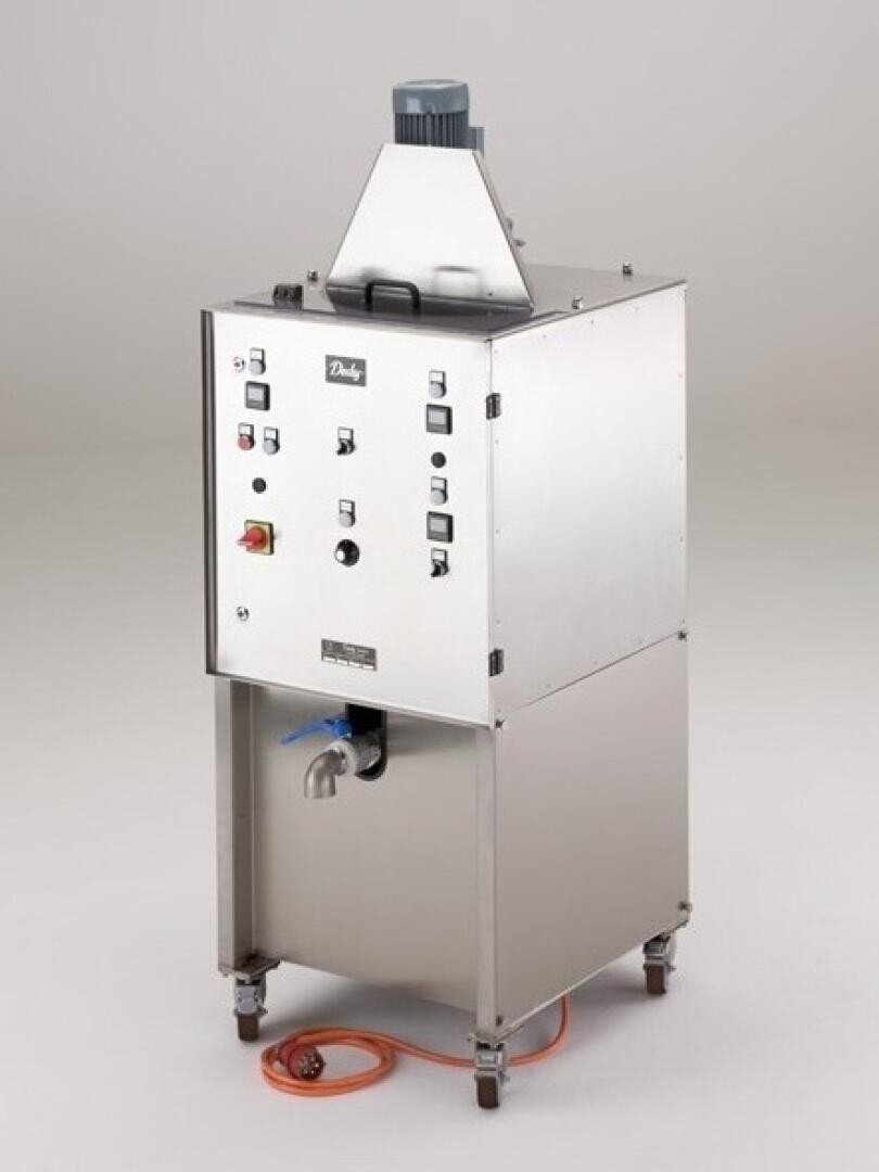 Eine Industriemaschine aus rostfreiem Stahl mit Bedientasten, Anzeigen und Kontrollleuchten auf der Vorderseite, auf Rädern montiert, mit einem orangefarbenen Stromkabel und einem Wasserhahn an der Unterseite. Die Marke Dadaji ist in der Nähe der Oberseite sichtbar.