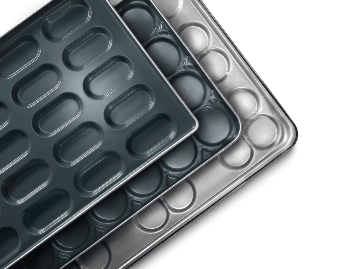 Drei gestapelte Backbleche aus Metall mit abgerundeten rechteckigen und ovalen Vertiefungen, von oben auf schwarzem Hintergrund dargestellt.