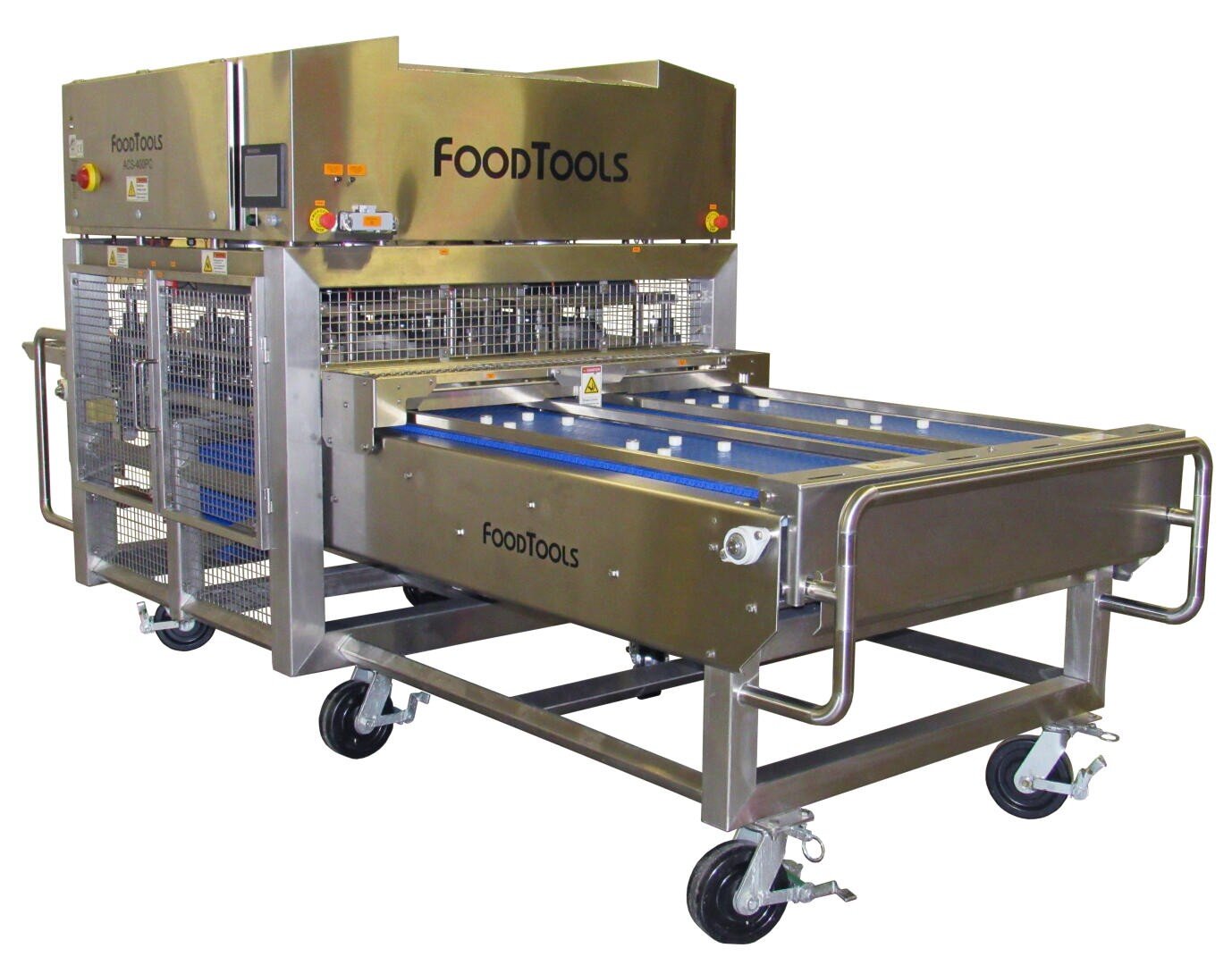 A stainless steel industrial food cutting machine labeled FoodTools, with conveyor belts, protective grates, control buttons, and wheels for mobility.