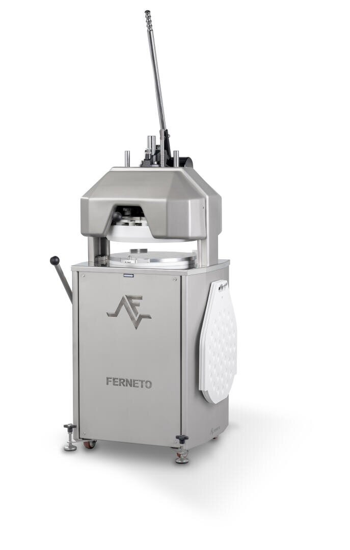 A stainless steel Ferneto dough divider machine with a lever and control handles, standing on adjustable feet, used for dividing dough in bakeries. An attached white board is folded against one side.