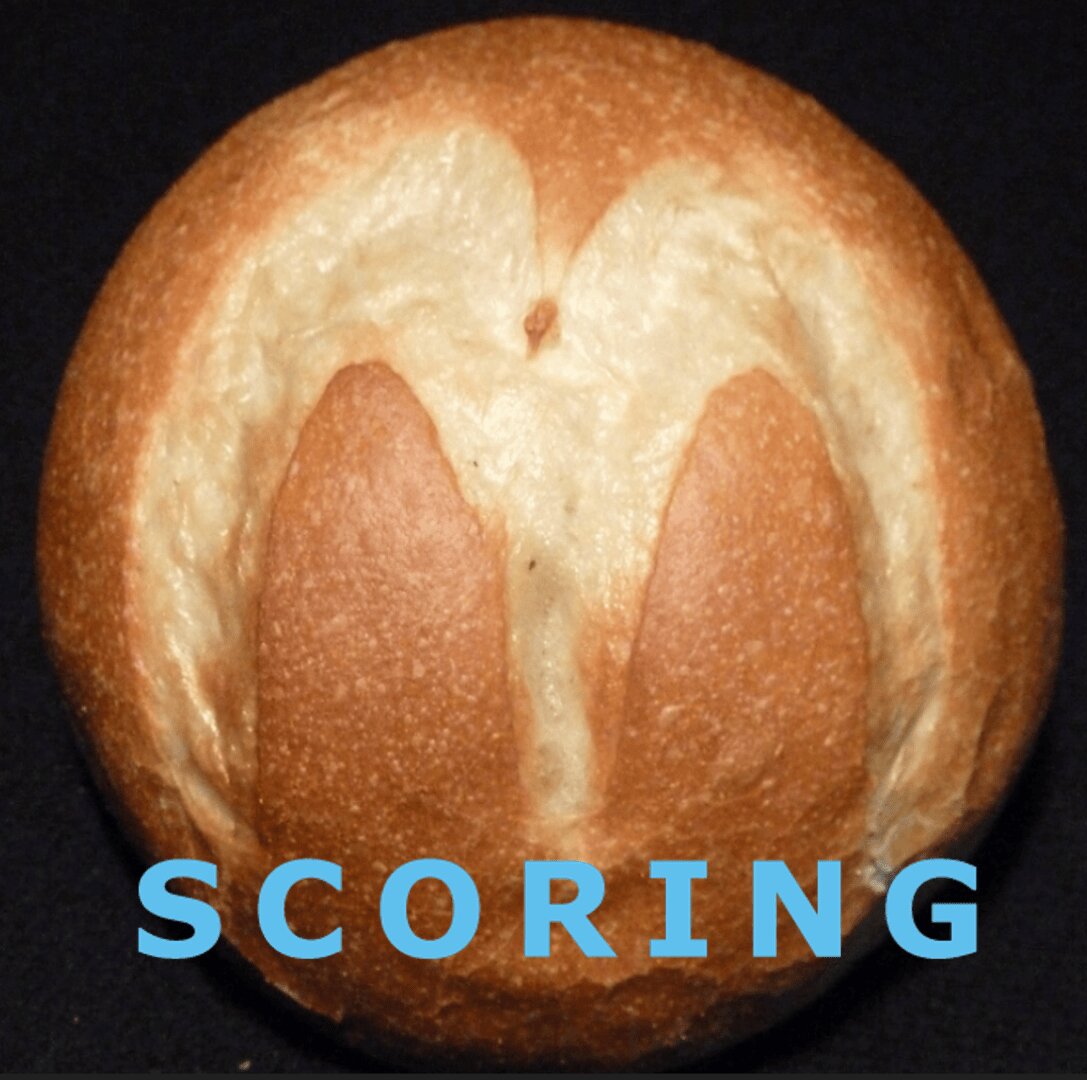 A round bread roll with a scored pattern resembling a heart or letter M on top, set against a black background. The word SCORING appears in large blue letters at the bottom.