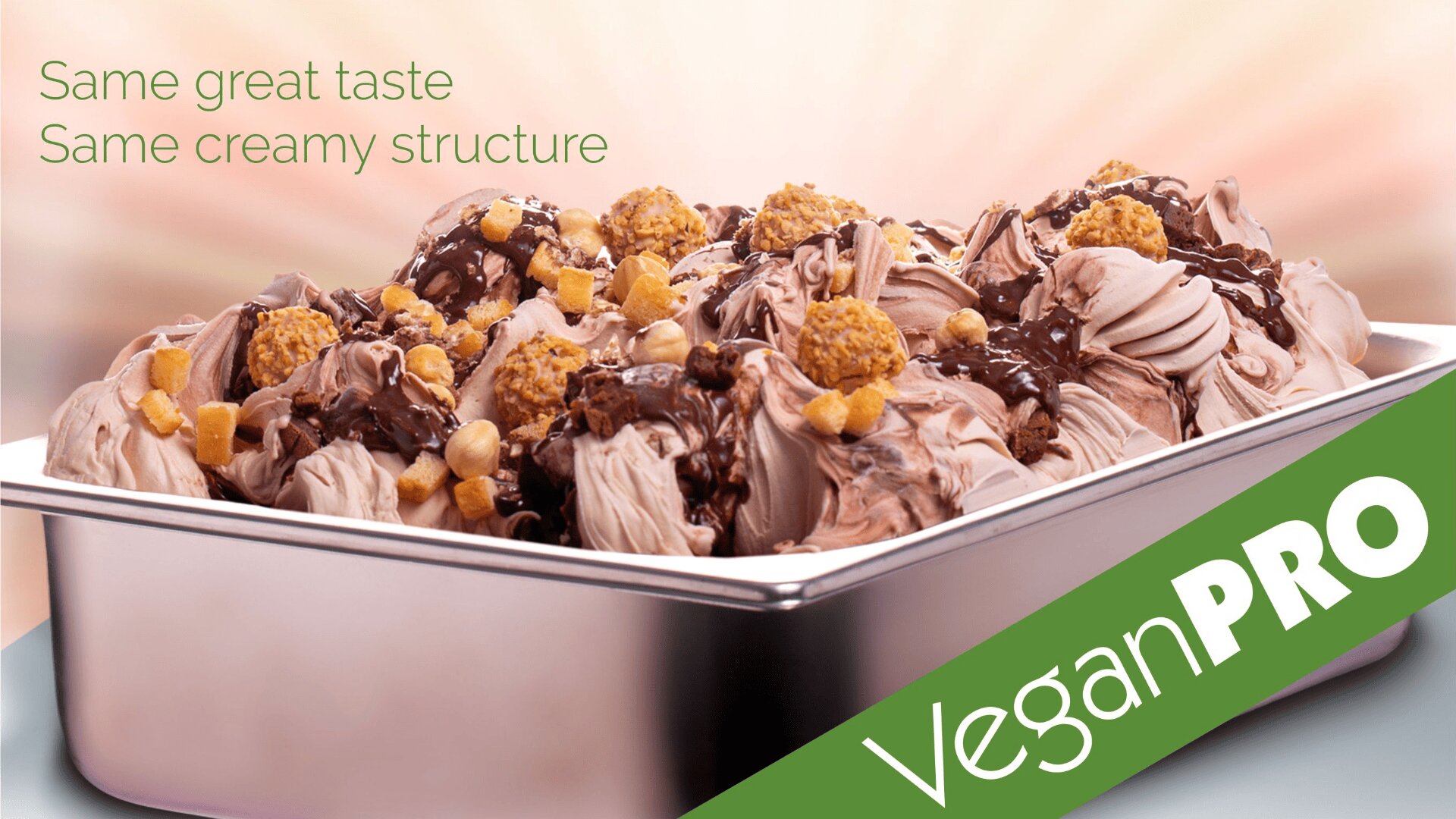A metal tray filled with creamy chocolate ice cream topped with chocolate sauce, cookie pieces, and nuts. Green text reads Same great taste, Same creamy structure with a Vegan PRO label across the corner.