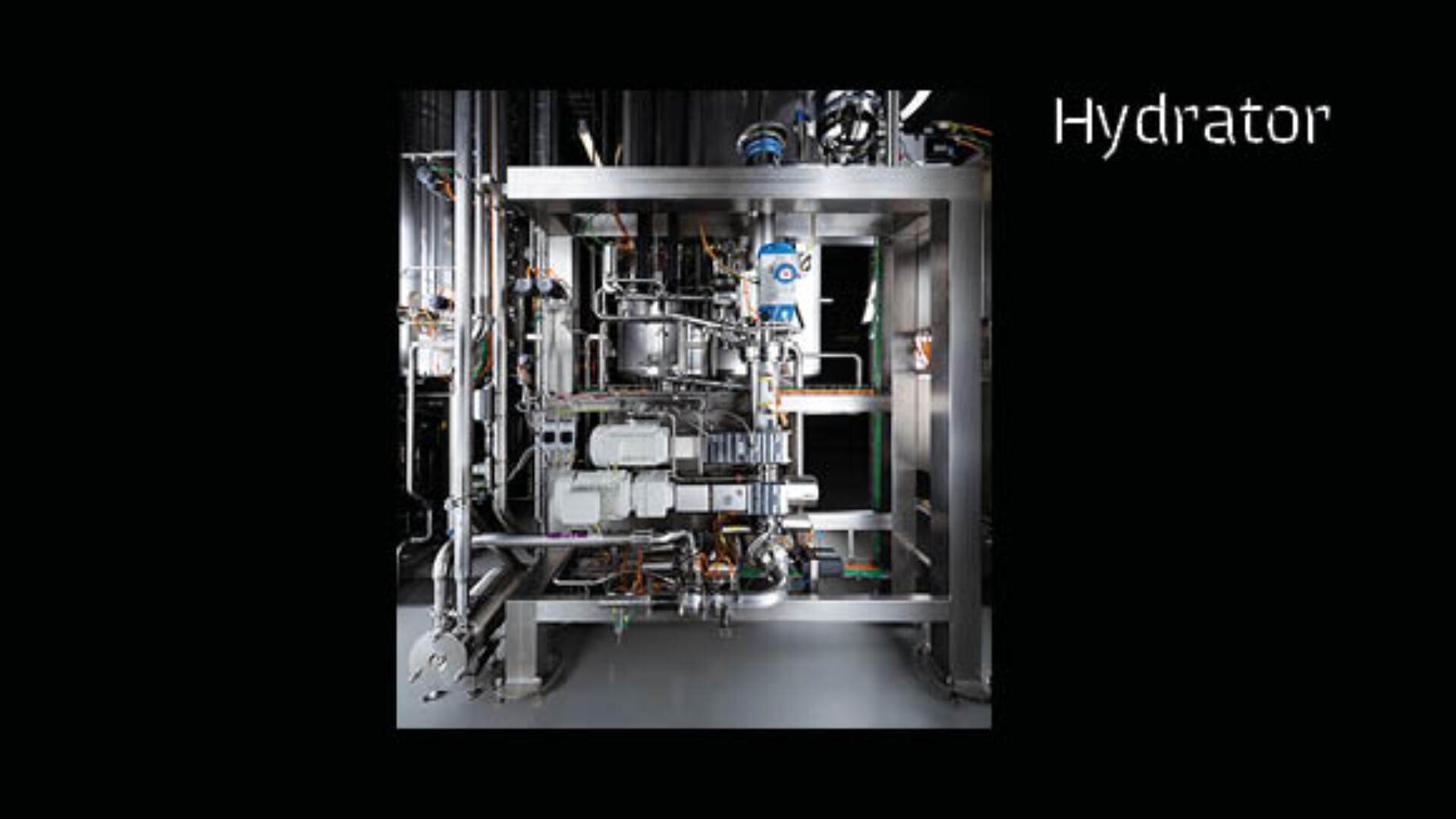 Eine komplexe Industriemaschine aus rostfreiem Stahl mit der Bezeichnung "Hydrator" und verschiedenen Rohren, Ventilen und Komponenten vor einem schwarzen Hintergrund.