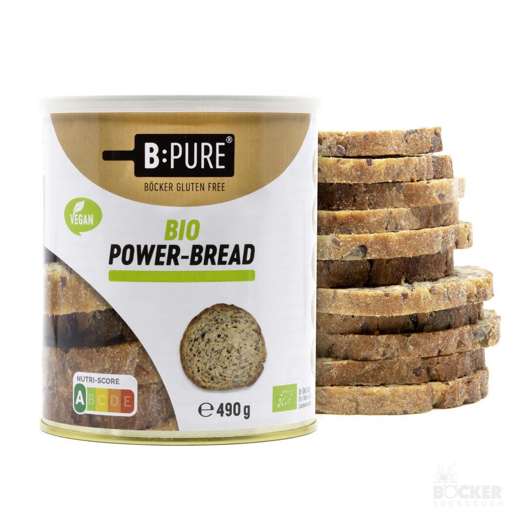 Eine Dose mit der Aufschrift B:PURE Bio Power-Bread steht neben einem Stapel geschnittenem Schwarzbrot. Die Dose ist als vegan und glutenfrei gekennzeichnet, hat den Nutri-Score A bis E und wiegt 490 g. Das Böcker-Sauerteig-Logo befindet sich in der unteren rechten Ecke.