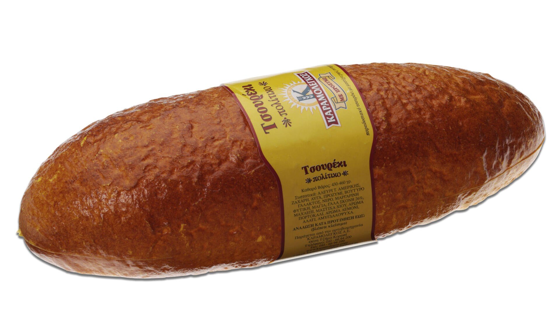 A large, oval loaf of tsoureki bread with a shiny, golden-brown crust, wrapped with a yellow label featuring Greek text and branding.