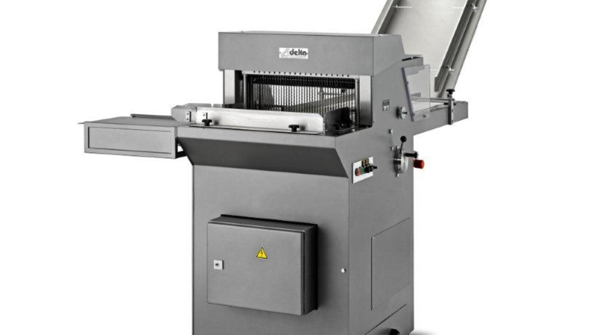 Eine kommerzielle Brotschneidemaschine mit einem Gehäuse aus Edelstahl, einem offenen Deckel, Bedientasten und Schlitzen zum Einlegen und Entnehmen der Brote, auf einem weißen Hintergrund stehend.