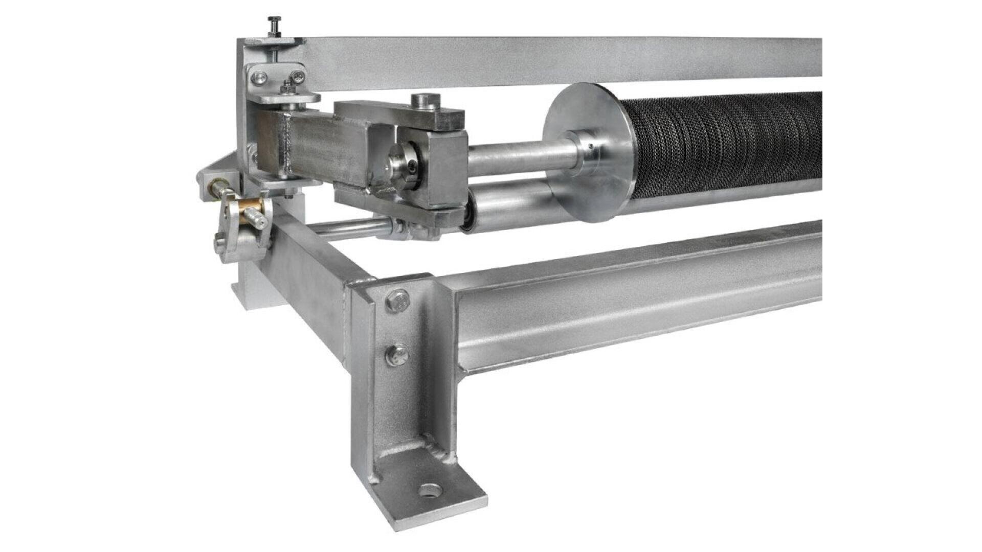 Close-up of a metallic industrial roller mechanism mounted on a sturdy frame, featuring a textured cylindrical roller and various bolts and joints.