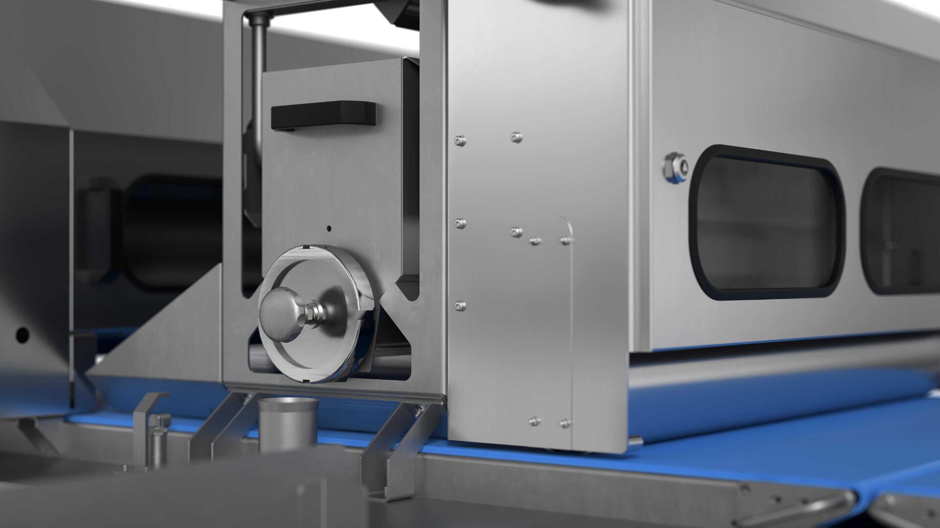 Close-up view of a modern industrial food processing machine with a metal exterior and a blue conveyor belt running through it. The machine features various components and windows for monitoring.