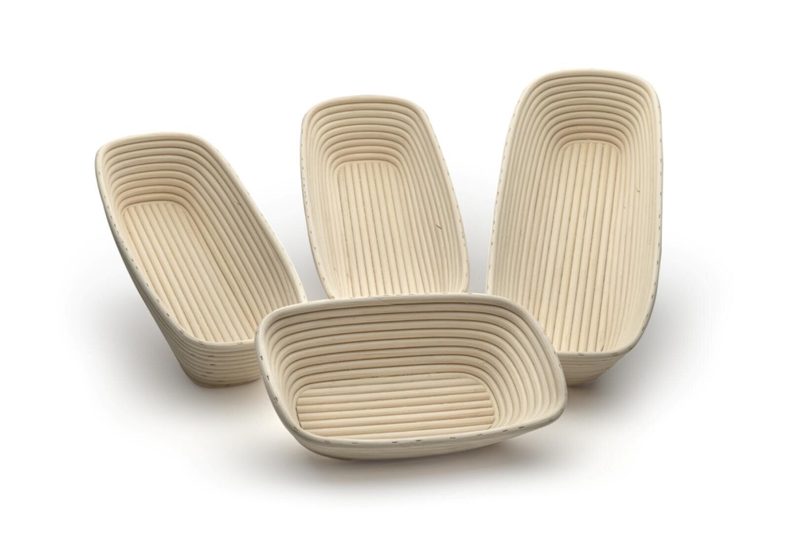 Vier rechteckige, ineinander geschachtelte, helle Gärkörbe mit geriffelter Innenseite, die zum Formen von Brotteig verwendet werden, sind auf einem weißen Hintergrund angeordnet.