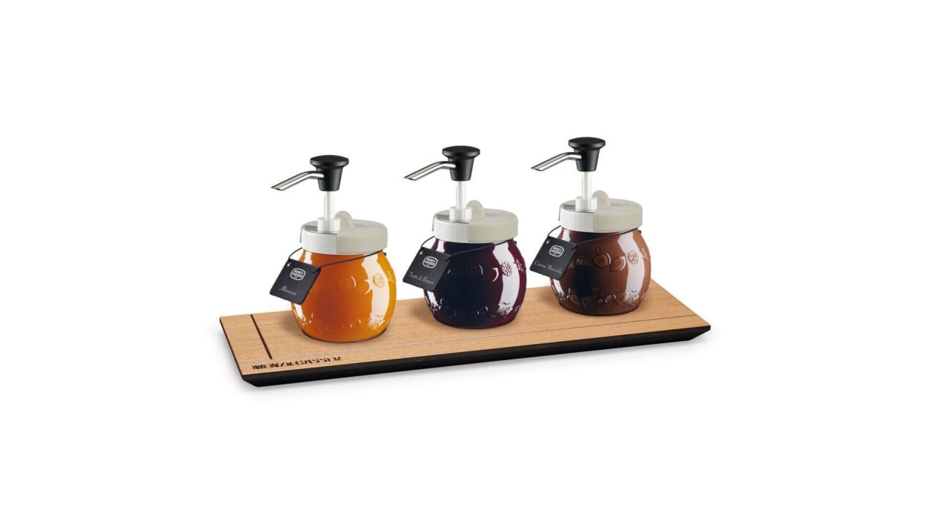 Three glass syrup dispensers with pump tops, filled with different colored syrups, are arranged on a wooden tray. Each dispenser has a small black tag attached to it. The background is white.