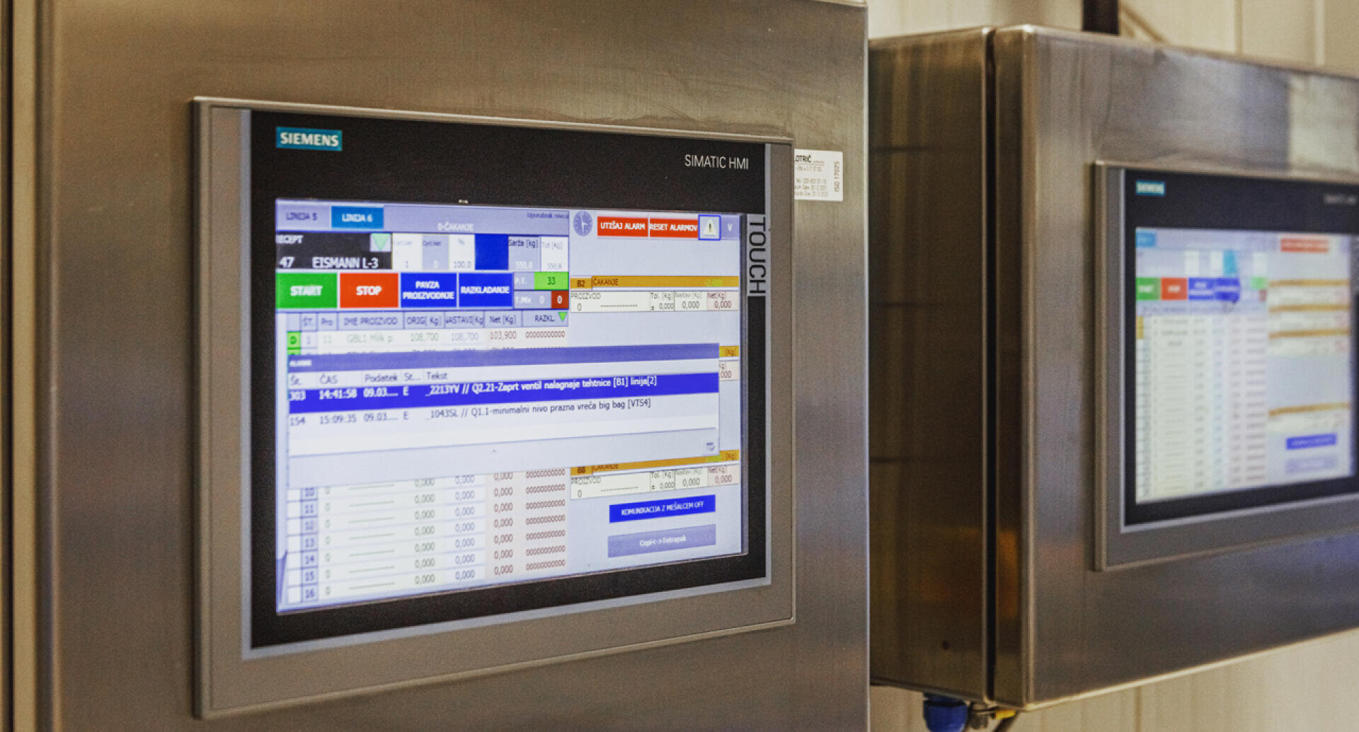 A close-up of an industrial touchscreen control panel displaying a Siemens SIMATIC HMI interface with various charts, controls, and status indicators; another similar screen is visible in the background.