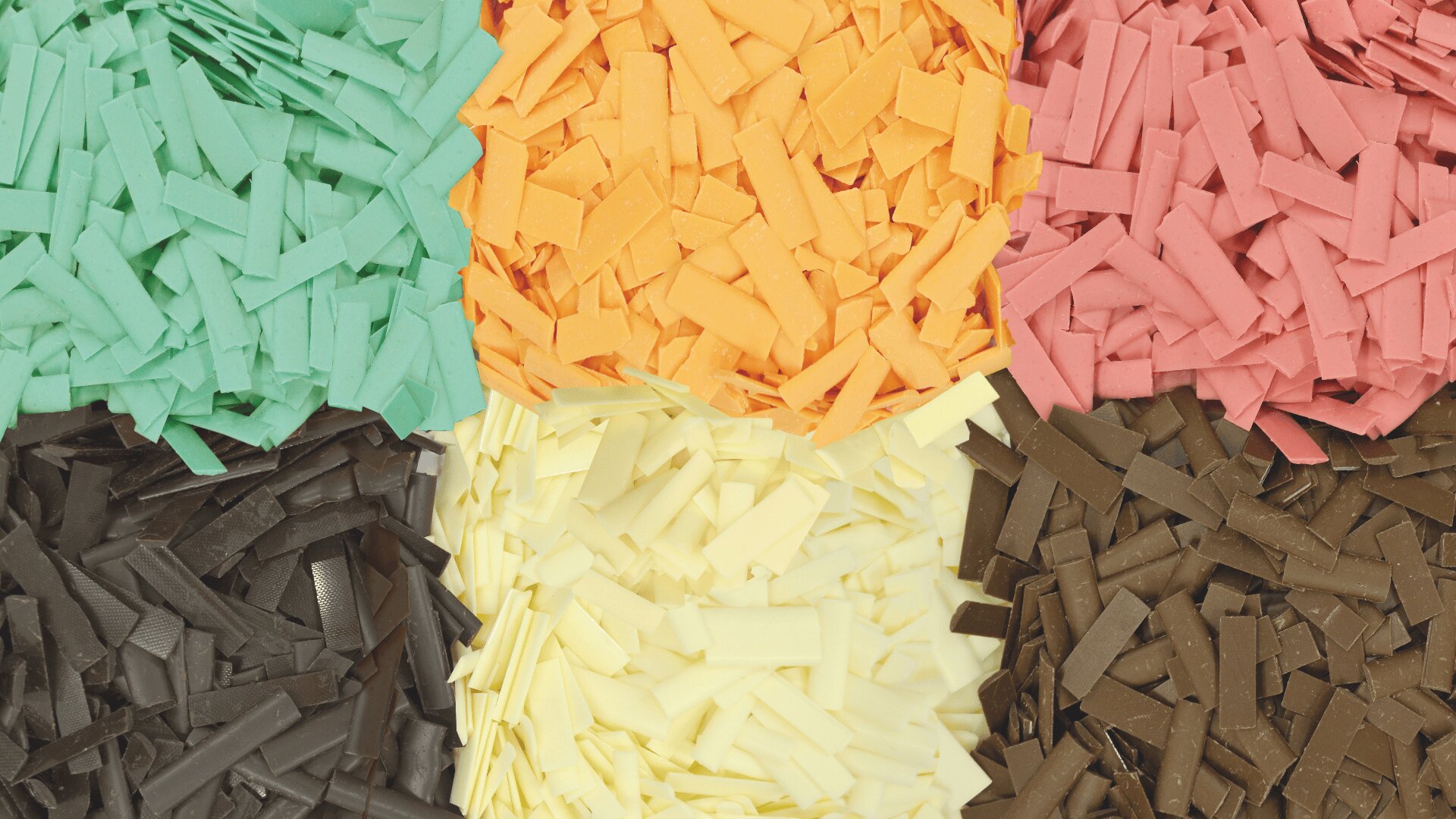 Six piles of colorful chocolate shavings are arranged in a grid, featuring green, orange, pink, brown, cream, and dark brown pieces. Each pile consists of small, thin, rectangular shards.