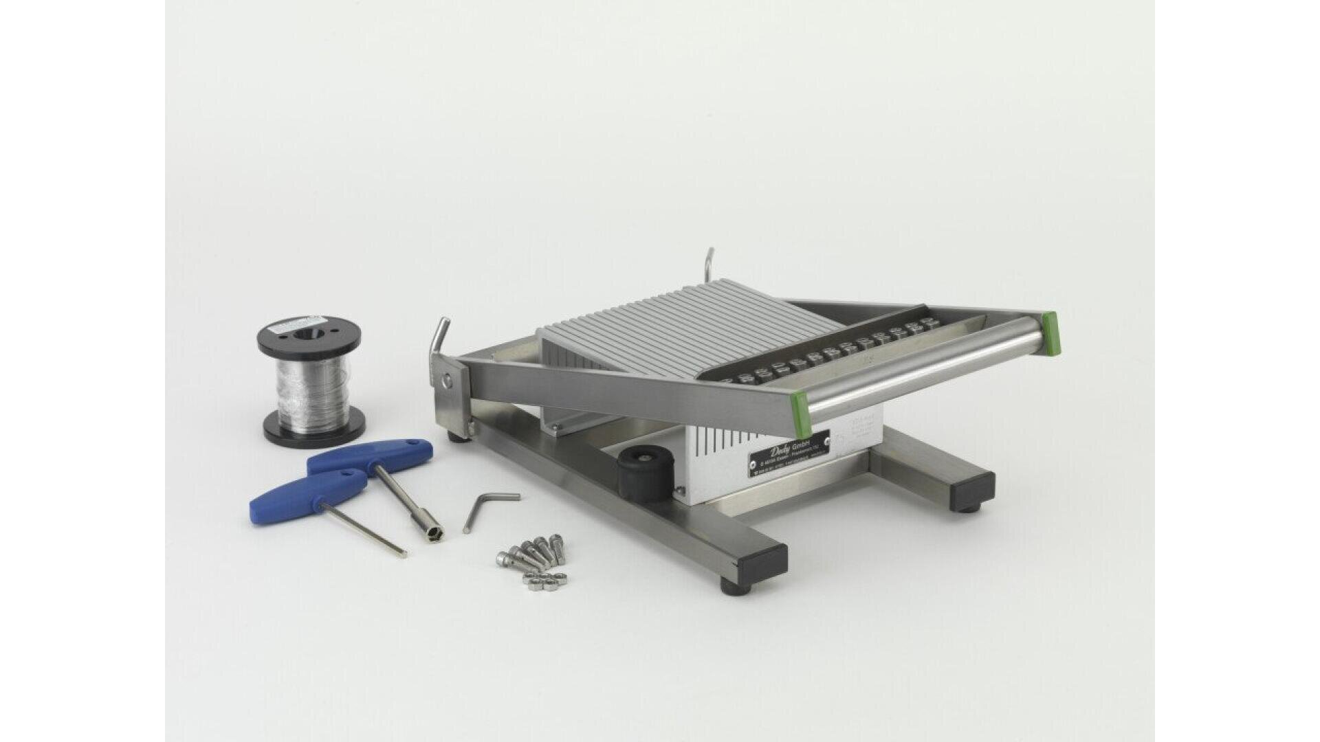 A metal wire cutter with a handle is displayed alongside a spool of wire, screws, two blue-handled tools, and an L-shaped hex key, all arranged on a plain white background.