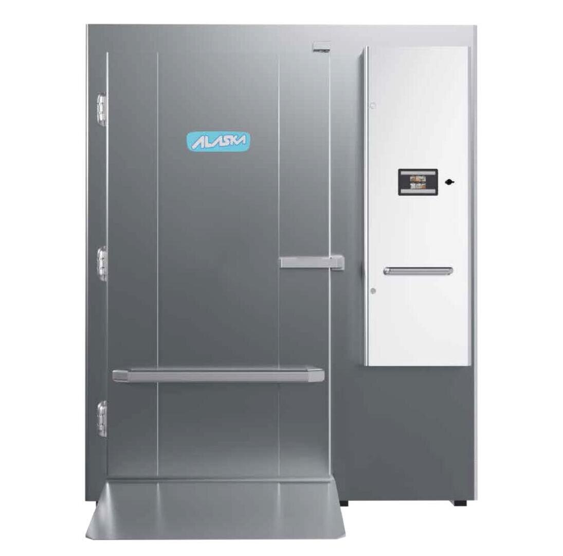 A large, industrial walk-in freezer with a gray door featuring the Alaska logo and a control panel on the right side. The door has two horizontal handles and a ramp at the base.