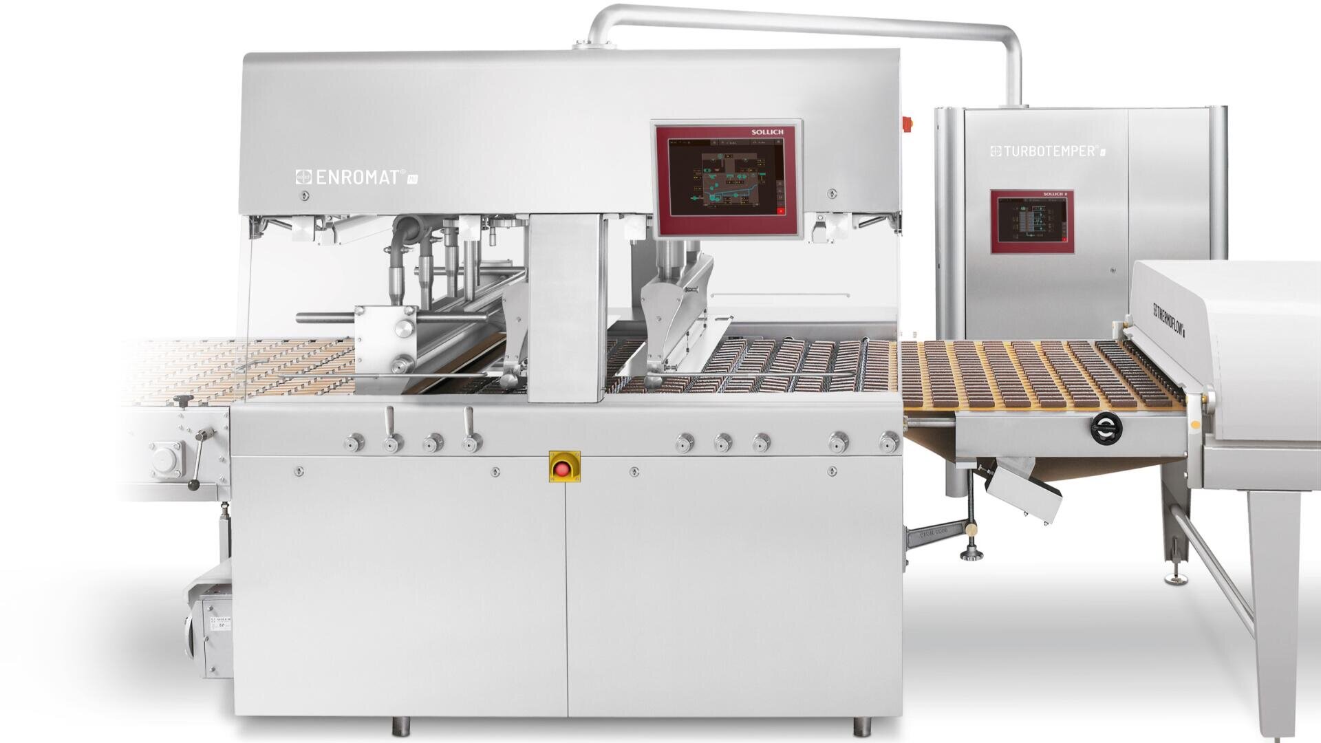 Eine industrielle Lebensmittelverarbeitungsmaschine aus Edelstahl mit digitalen Anzeigen verarbeitet reihenweise Süßwaren oder Backwaren auf einem Förderband, das für die automatisierte Produktion in einer Fabrik ausgelegt ist.