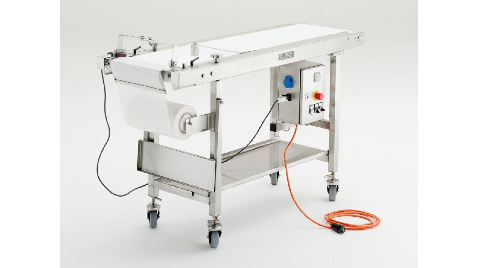 A stainless steel conveyor belt machine on wheels with a control panel, power cords, and a white belt, set against a plain white background.