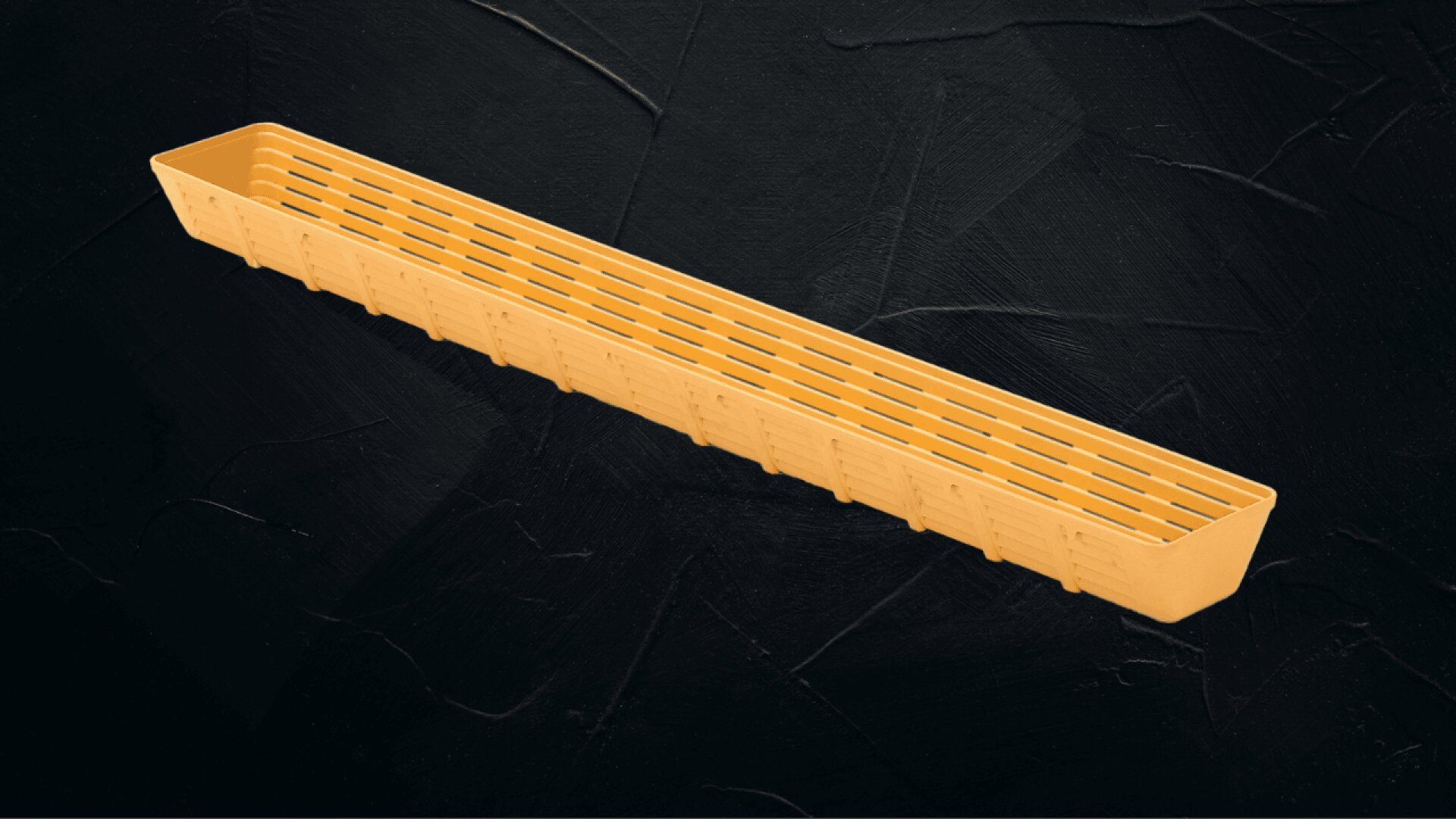 Ein langer, rechteckiger, hellbrauner Kunststoffkorb mit Schlitzen steht auf einem dunkel strukturierten Hintergrund.