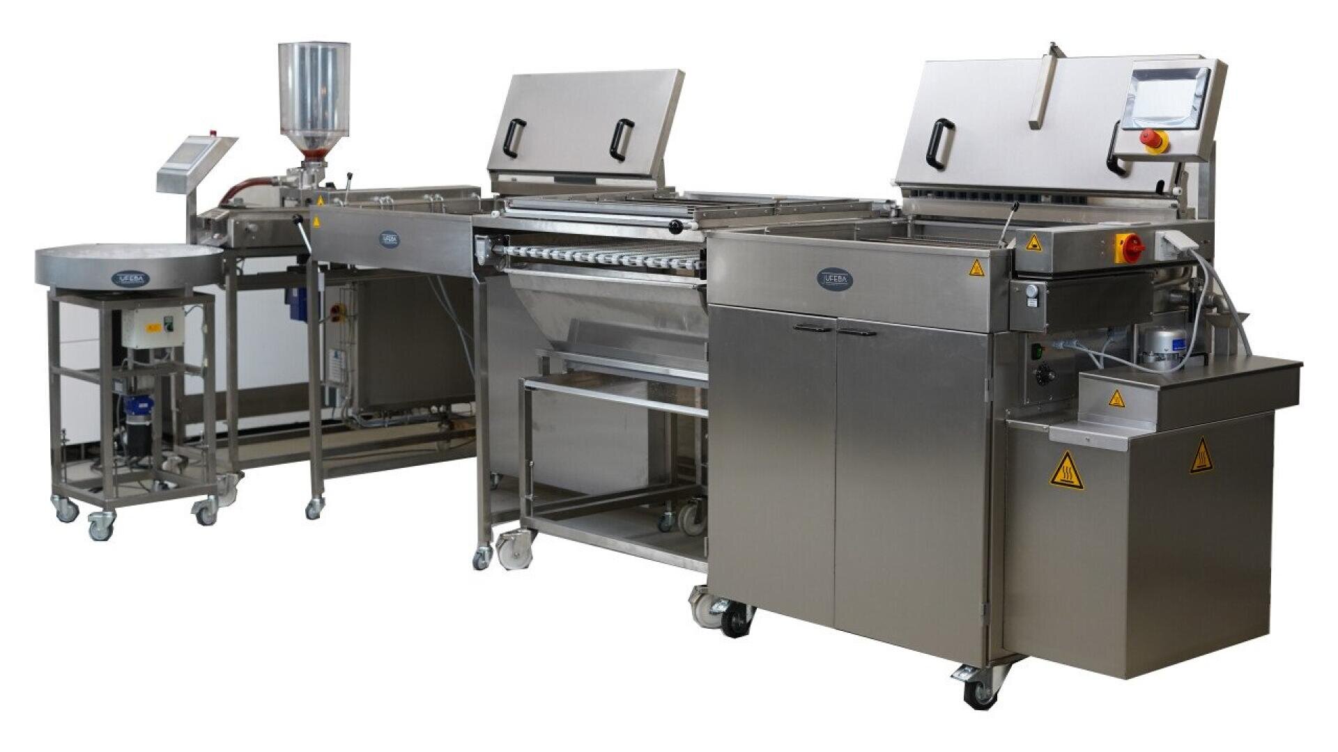 Stainless steel industrial food processing machine with conveyor belts, control panels, and large compartments, designed for automated production, standing on wheels for mobility.