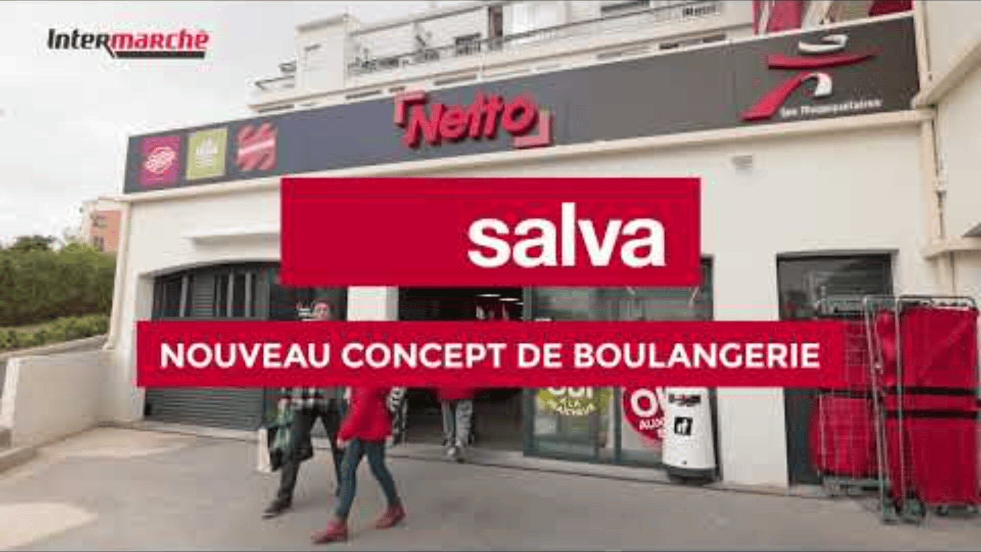 Menschen gehen am Eingang eines Netto-Geschäfts vorbei, auf dem die Texte „Intermarché“, „Salva“ und „NOUVEAU CONCEPT DE BOULANGERIE“ deutlich sichtbar auf roten und weißen Bannern zu sehen sind.