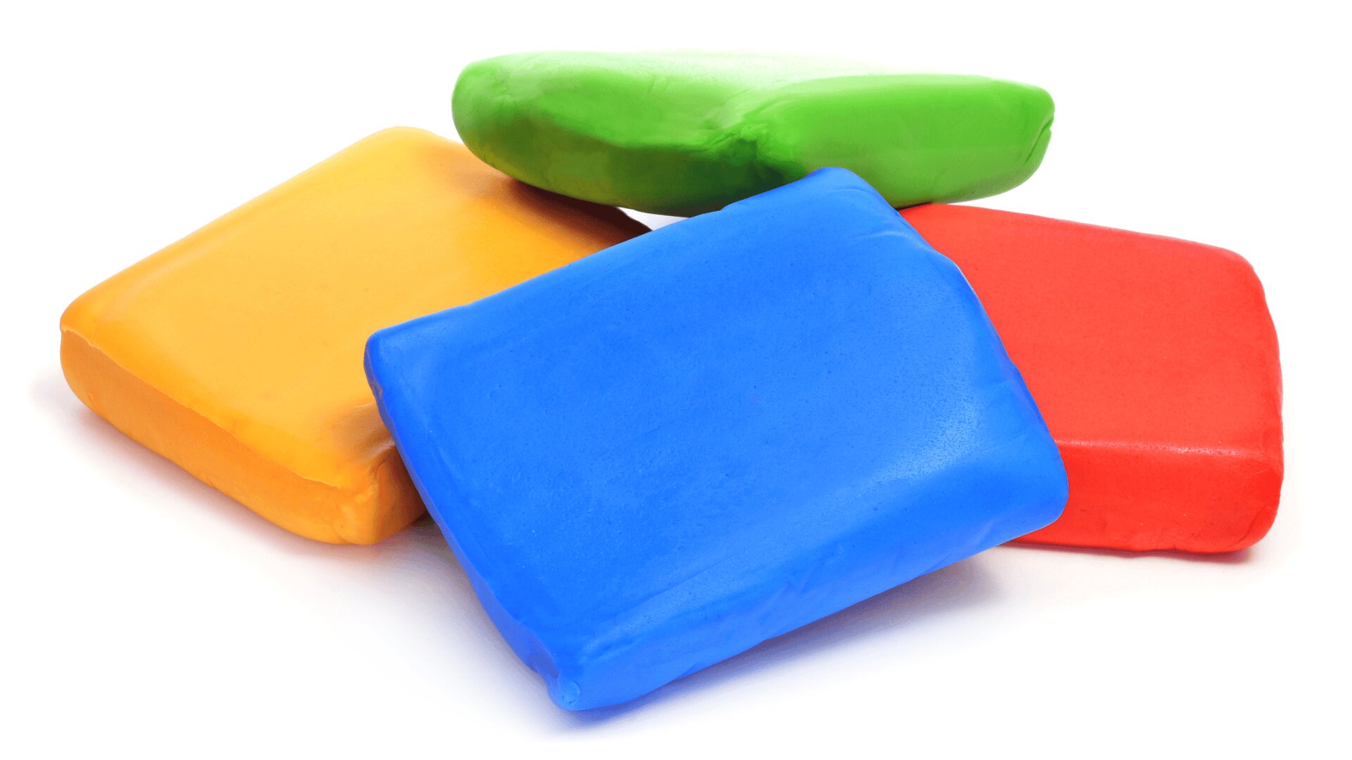 Four colorful rectangular blocks of modeling clay—blue, red, yellow, and green—are stacked in a pile on a white background.