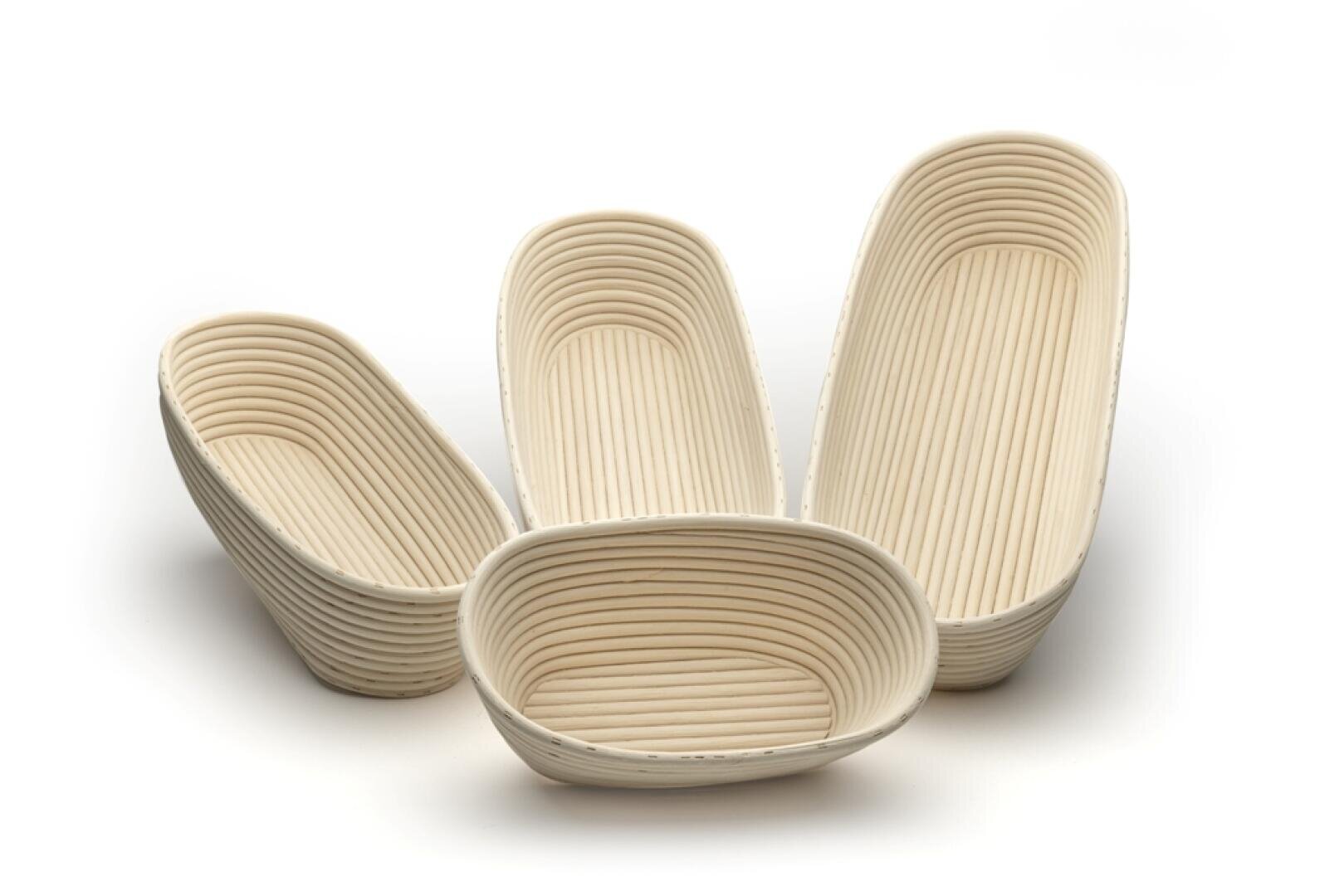 Vier ovale, gerippte Gärkörbe, auch Bannetons genannt, sind auf einem weißen Hintergrund angeordnet. Die Körbe sind leer und variieren in ihrer Größe, wobei zwei aufrecht stehen und zwei auf der Seite liegen.