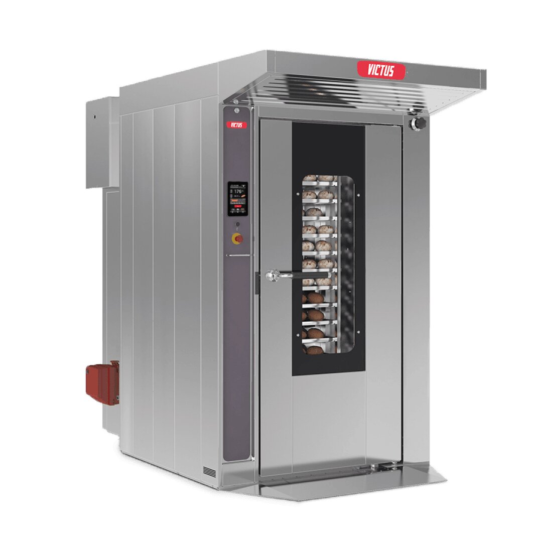A large industrial stainless steel bakery oven with a glass door showing multiple trays of bread inside. The oven has a control panel on the side and is labeled VICTUS at the top.