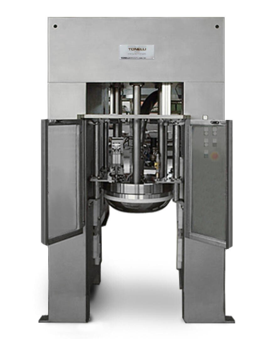 Front view of a large industrial mixing machine made of stainless steel, with open side panels revealing the mixer mechanism and a bowl beneath. The brand Tonelli is visible on a label at the top.