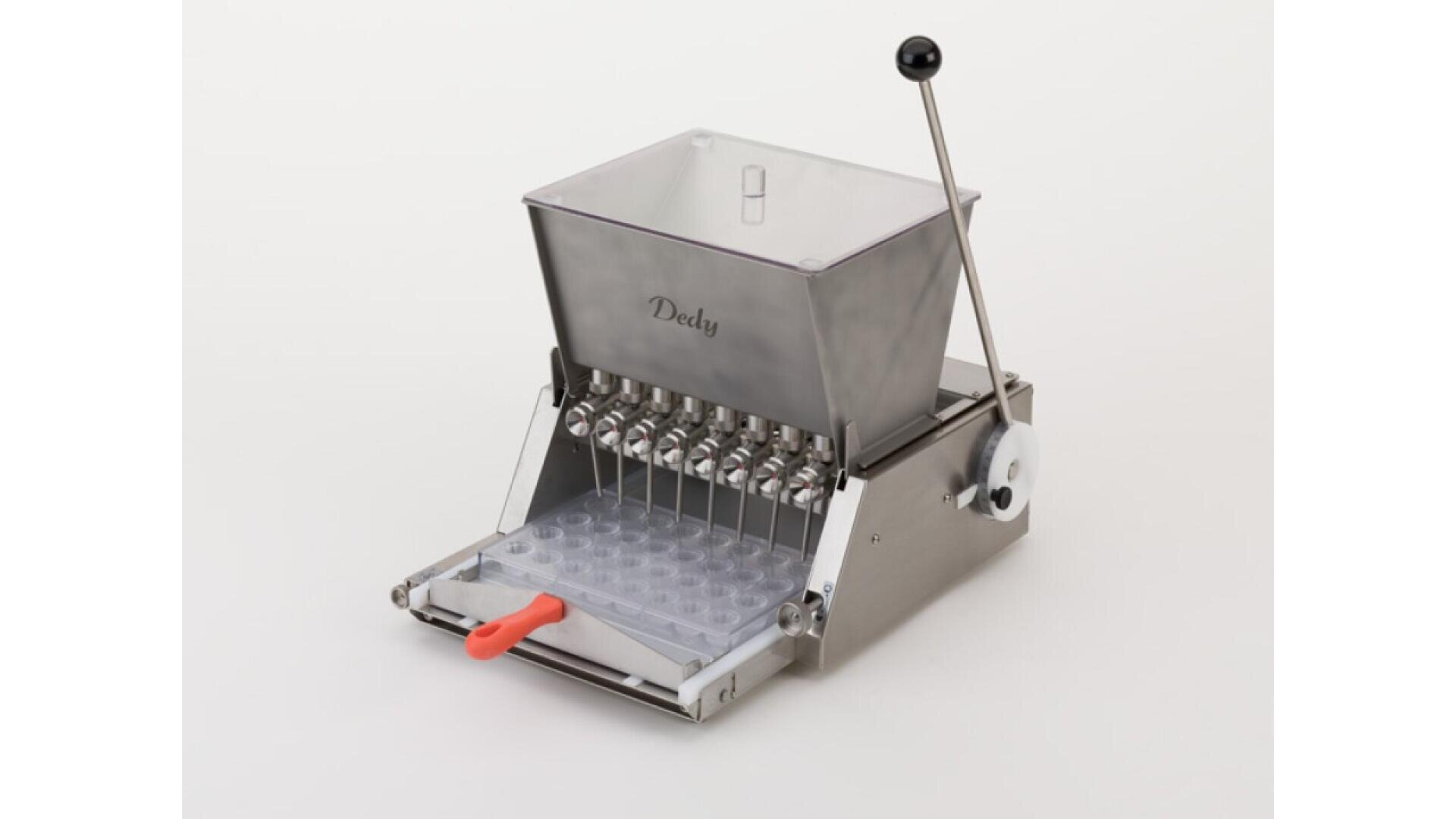 A stainless steel confectionery machine with a clear plastic hopper, lever, and multiple nozzles, used for filling molds. The machine is labeled Dedy and has a mold tray positioned underneath the nozzles.