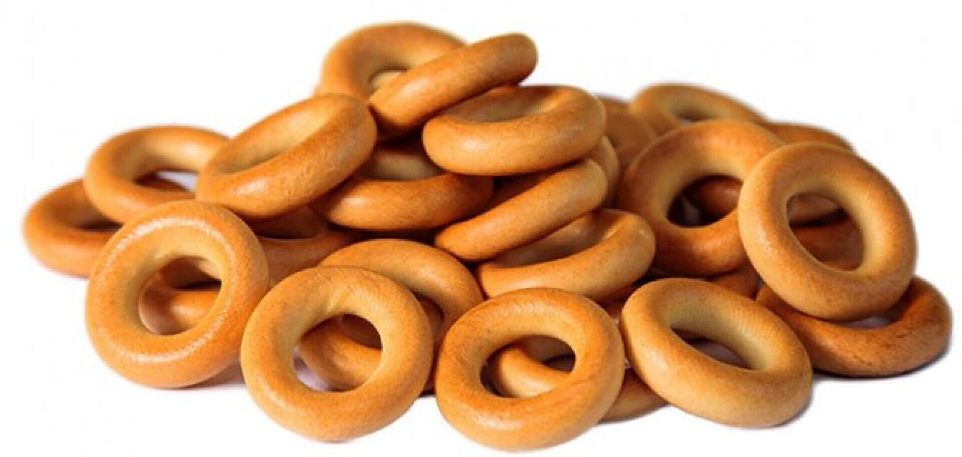 Ein Stapel runder, goldbraun gebackener Brotringe, bekannt als Bagels oder Baranki, gestapelt auf einem weißen Hintergrund.