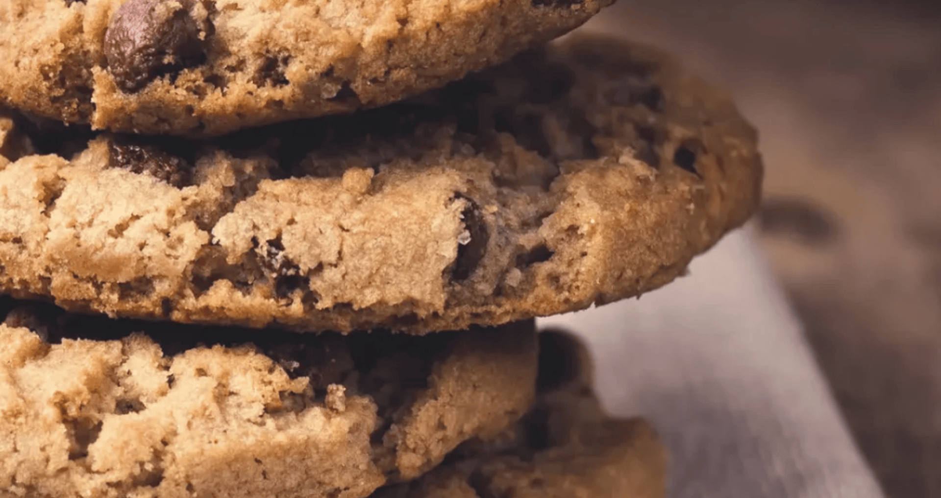 Eine Nahaufnahme eines Stapels Schokoladenkekse auf einer Serviette, die die bröckelige Textur und die Schokoladenstücke zeigt.