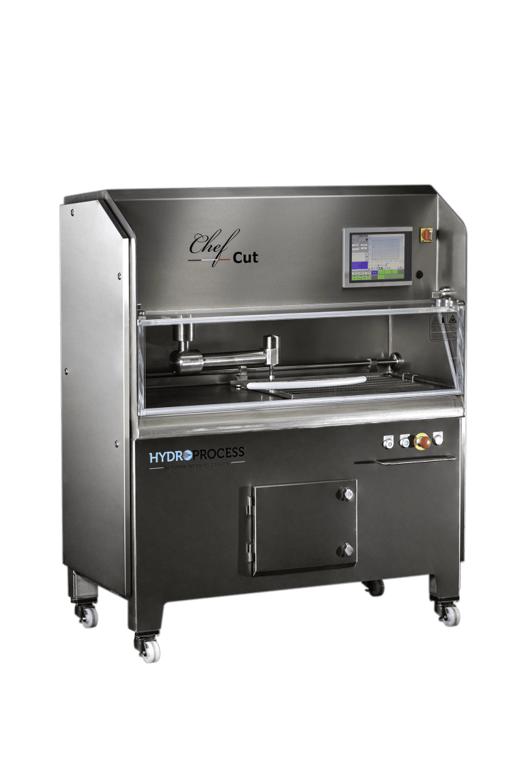 A large, stainless steel industrial food processing machine with a touchscreen display, labeled “Chef Cut HYDROPROCESS,” featuring wheels for mobility and control buttons on the front panel.