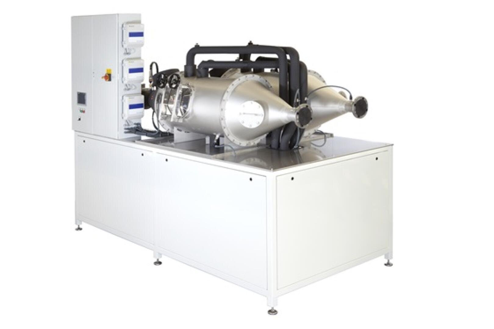 Industrielle Laborausrüstung mit einem großen weißen Schrank, an dem zylindrische Kammern aus Edelstahl, Bedienfelder und verschiedene mechanische Komponenten angebracht sind.