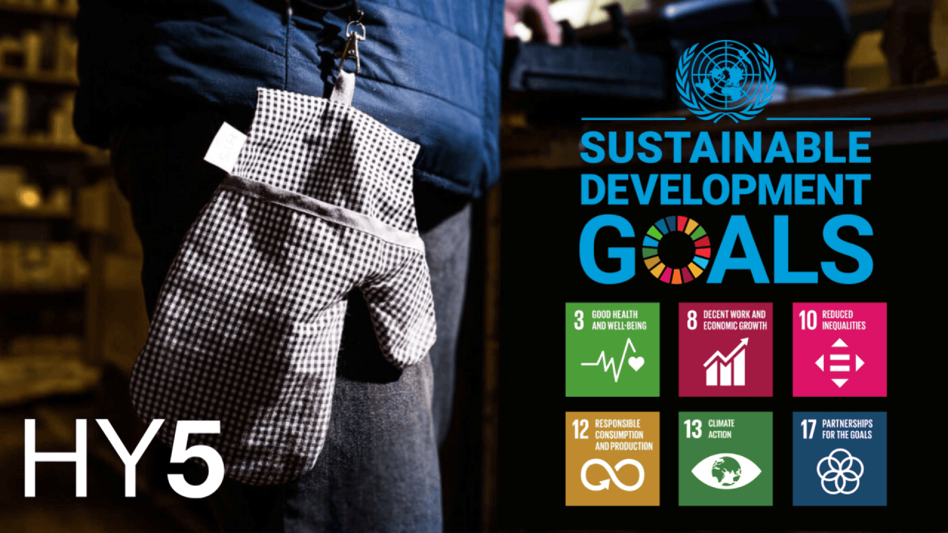 A person with a prosthetic hand in a checkered glove stands beside a display of six UN Sustainable Development Goals icons and the UN logo. HY5 is written in bold white letters in the lower left corner.
