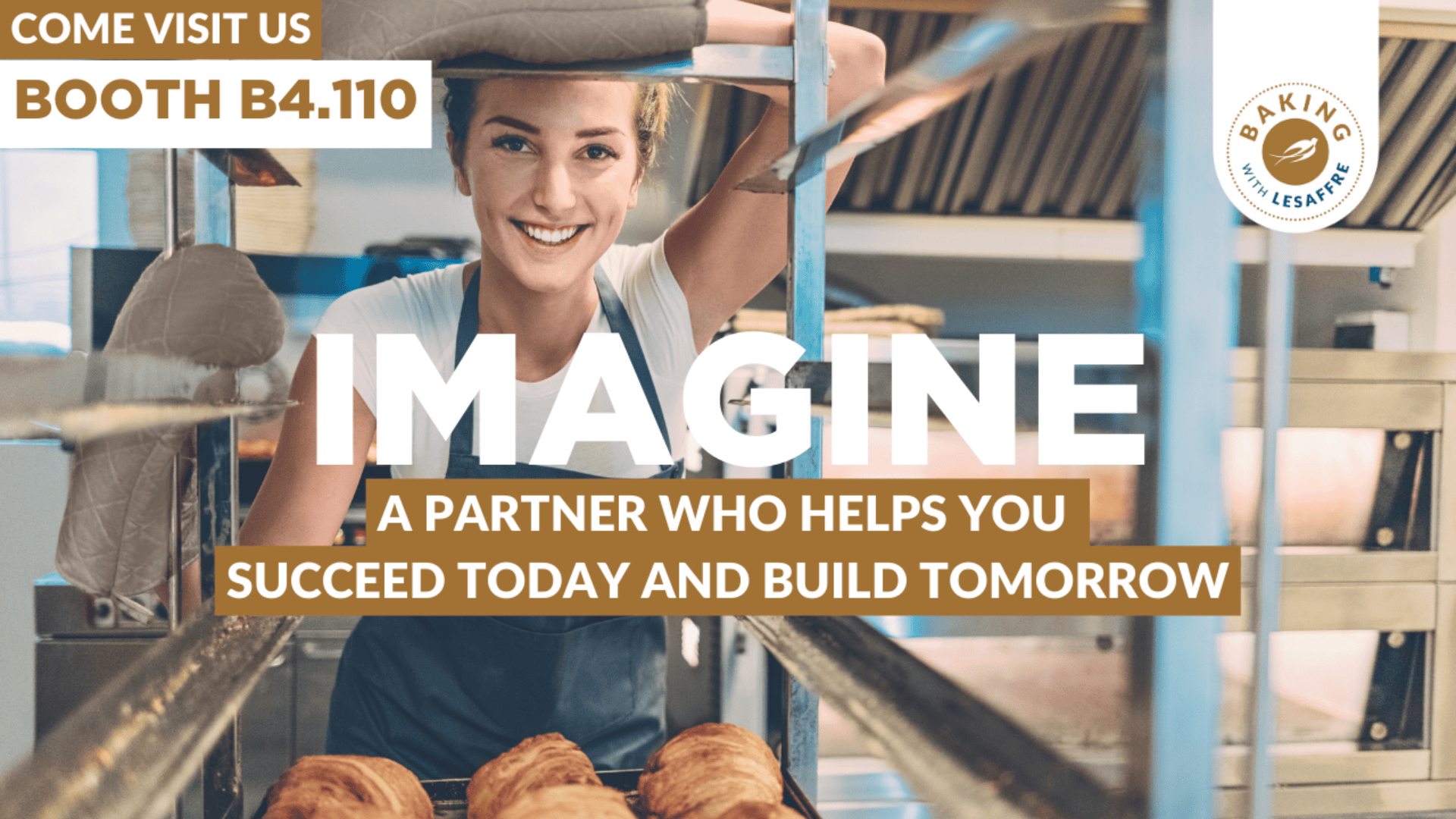 A smiling baker places fresh bread on a rack in a bakery. Text reads, “Come visit us Booth B4.110. Imagine a partner who helps you succeed today and build tomorrow.” Baking Industry Lesaffre logo appears in the corner.