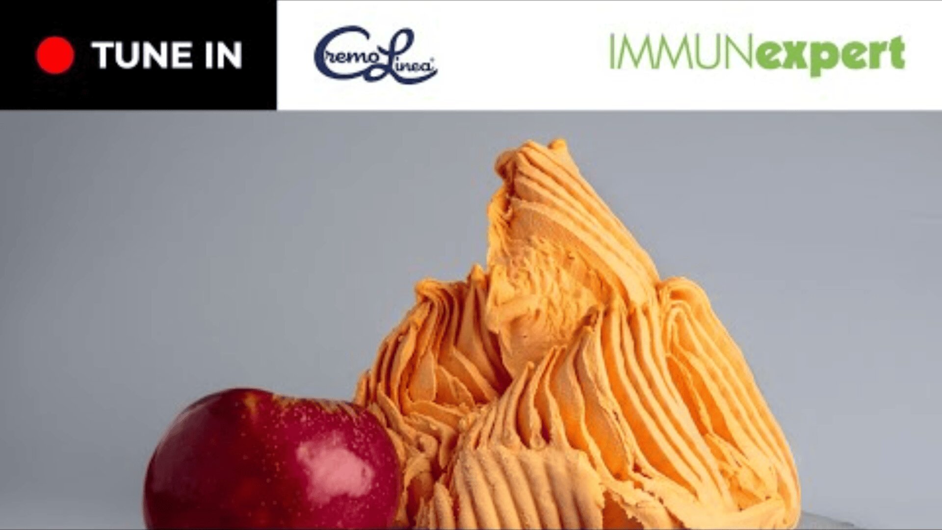 Orangeneis in einem Wirbelhaufen neben einem roten Apfel. Oben befinden sich die Logos von TUNE IN, CremoLinea und IMMU Nexpert auf weißem Hintergrund.