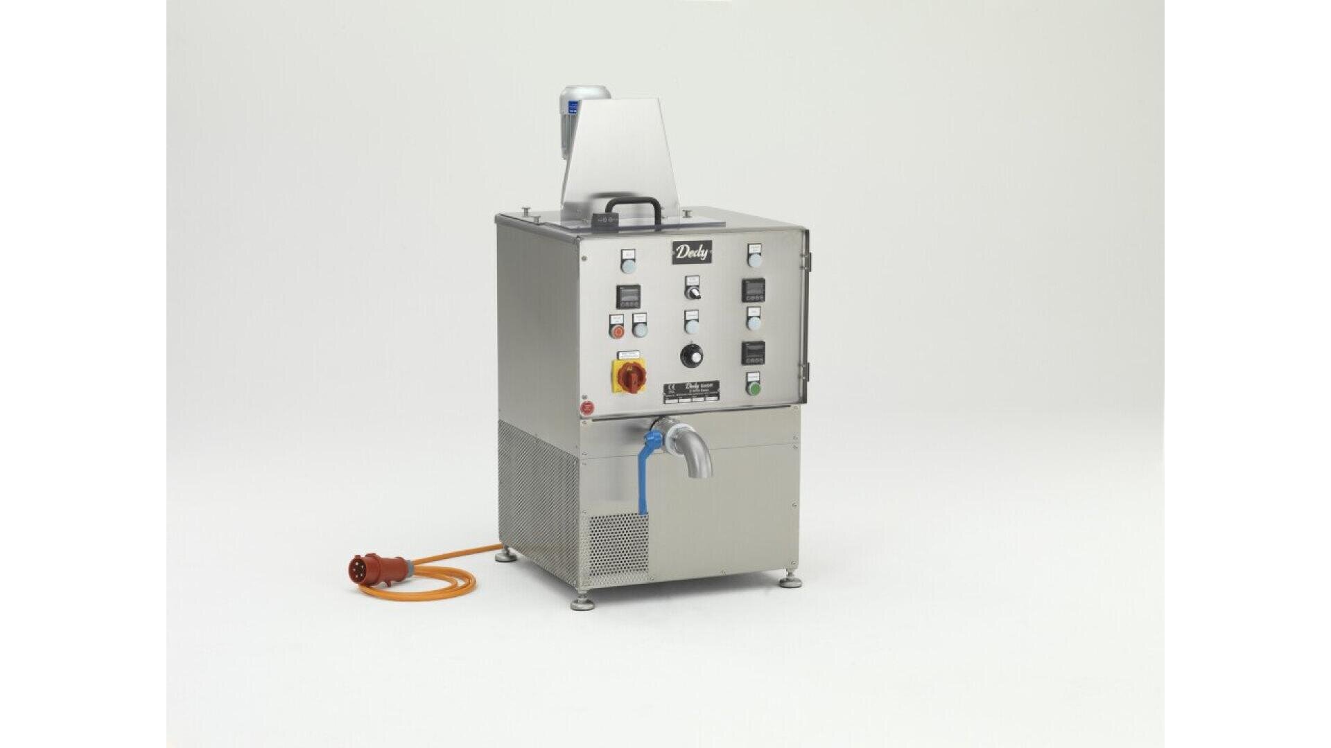 A stainless steel industrial machine with control buttons, dials, and a spout at the front, connected to an orange power cable, set against a plain white background.