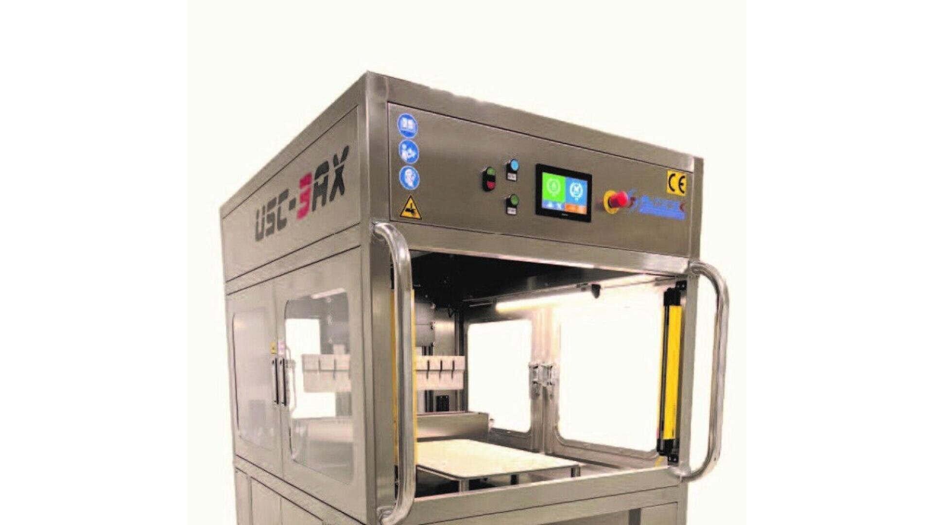 A stainless steel industrial machine with a digital control panel, safety features, and transparent doors, set against a plain background.