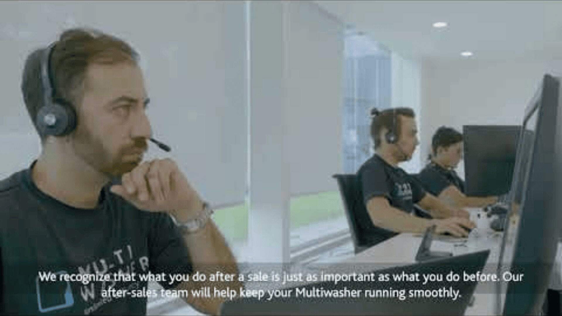 Drei Männer mit Headsets sitzen in einem hellen, modernen Büro an Schreibtischen und arbeiten an Computern. Unten wird die Bedeutung des Kundendienstes für Multiwasher-Produkte hervorgehoben.