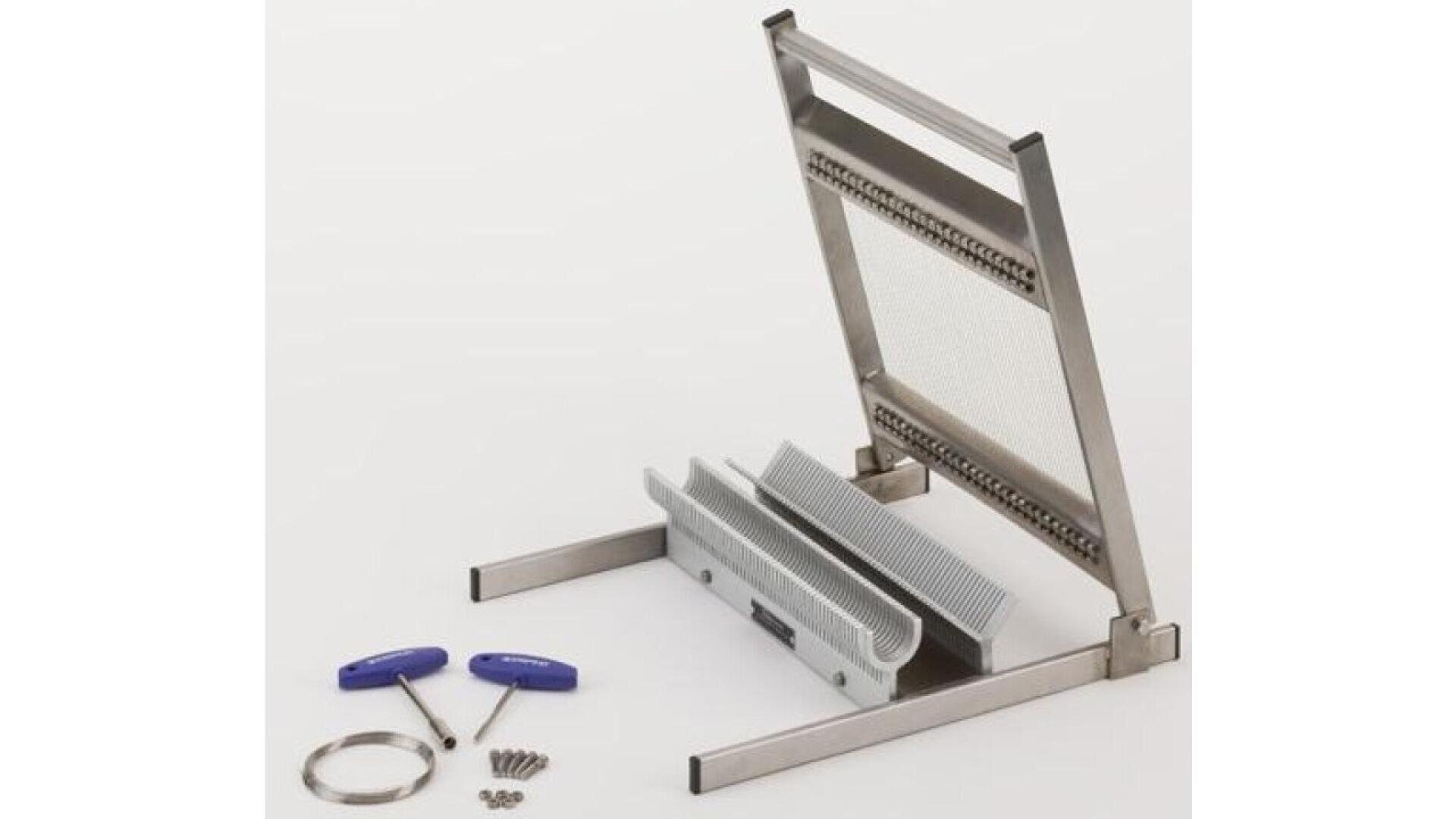 A stainless steel wire cutter tool with a frame, wire grid, and comb-like attachment, alongside screws, a metal ring, and two blue-handled wrenches, all arranged on a white surface.