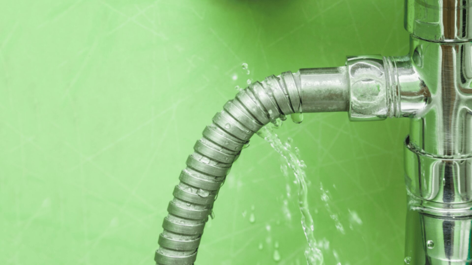 A metal pipe with a flexible section has a water outlet against a light green background. Streams of water visibly emerge from the connection.