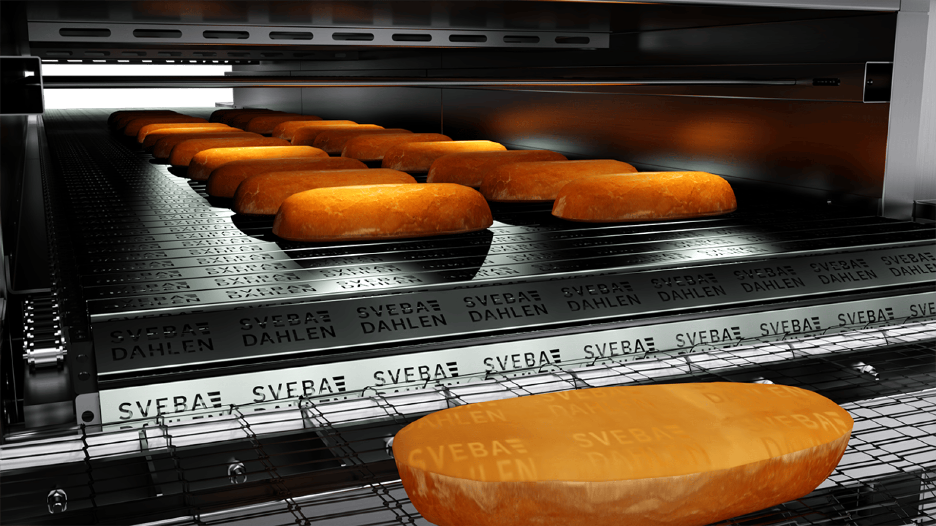 Rows of oval loaves of bread are moving on a conveyor belt inside an industrial oven labeled SVEBA DAHLEN, baking as they travel through the machine.