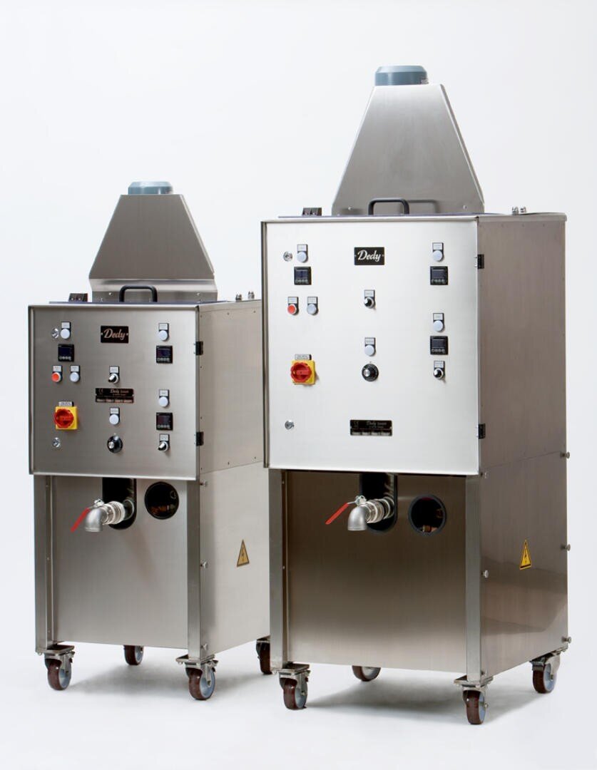 Zwei Industriemaschinen aus rostfreiem Stahl auf Rädern, jeweils mit Bedienfeldern, Knöpfen, Schaltern, Warnschildern und Ausgüssen am Boden, vor einem schlichten weißen Hintergrund.