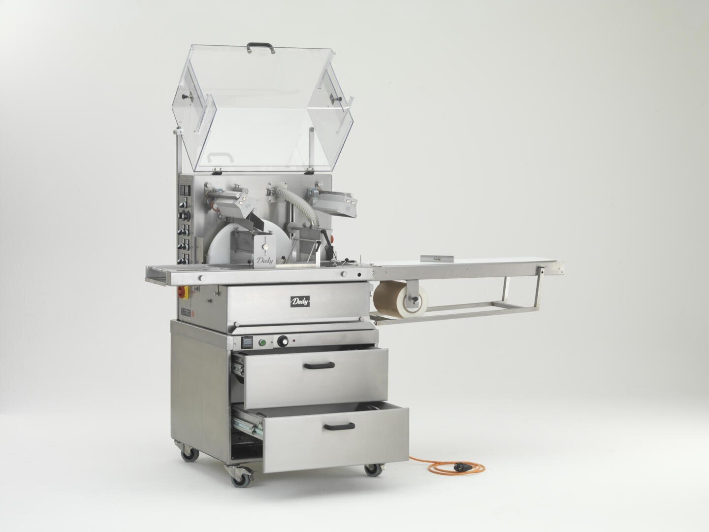 Eine industrielle Lebensmittelverpackungsmaschine aus Edelstahl mit offenem Deckel, Bedienfeld, Rollen, Schalen, Schubladen und einem orangefarbenen Stromkabel vor einem schlichten weißen Hintergrund.