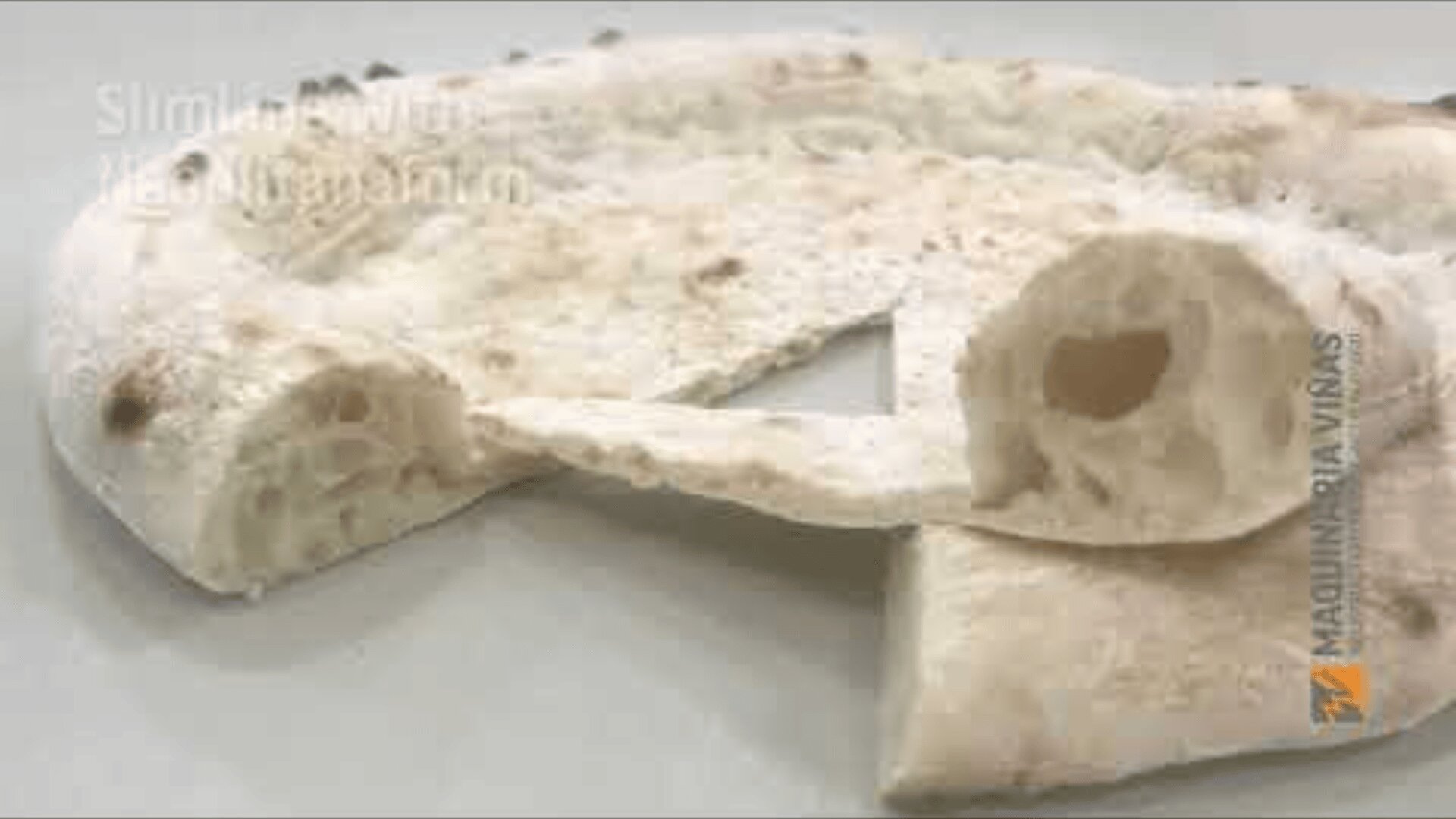 A close-up of a folded piece of flatbread or pizza crust, showing its airy, crispy texture with visible bubbles inside. The background is monochrome and bright.