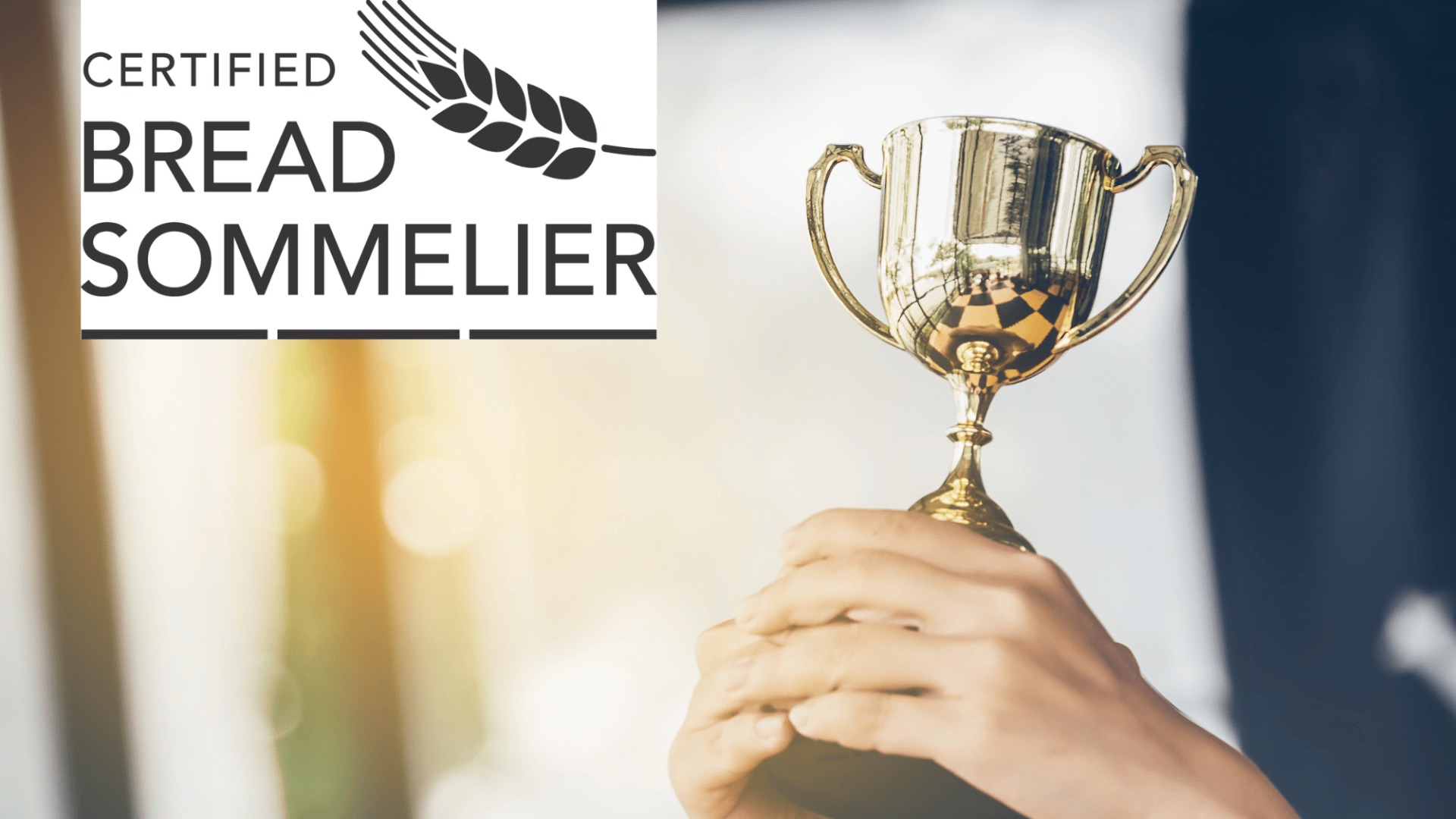 Eine Person hält eine goldene Trophäe hoch. In der Ecke steht ein Schild mit der Aufschrift "Certified Bread Sommelier" und einer stilisierten Weizengrafik. Im Hintergrund scheint das Sonnenlicht.