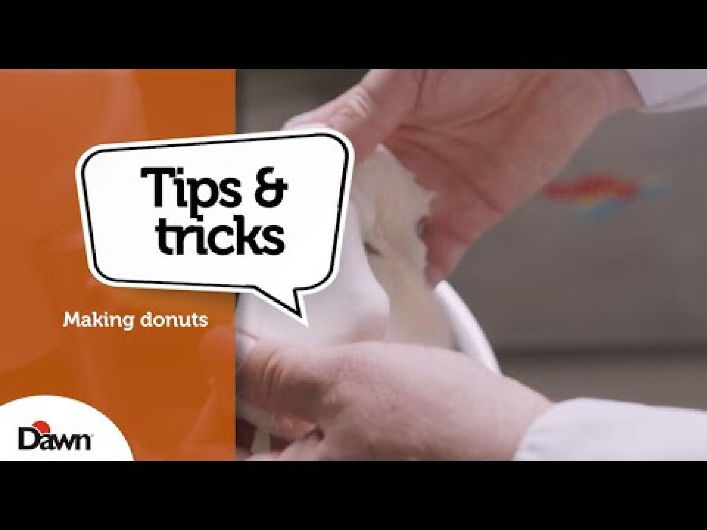 Close-up of hands shaping dough with text overlay: Tips & tricks and Making donuts. Dawn logo in the bottom left corner.