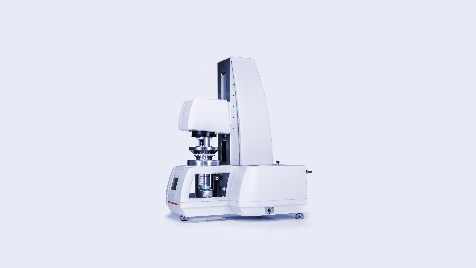 A laboratory rheometer with a sleek, modern design, featuring a vertical measuring head and a digital control panel, standing on a flat surface against a plain light background.