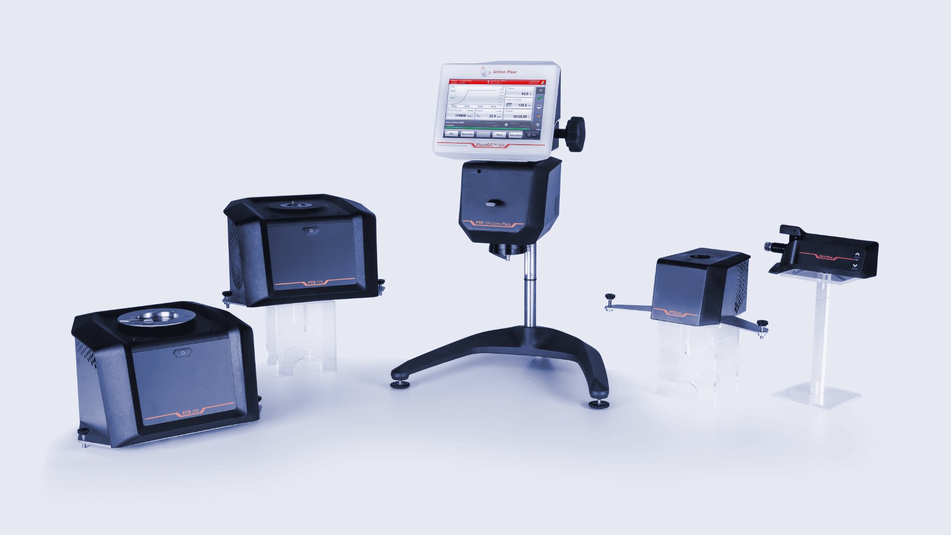 Four black scientific instruments and a digital control unit with a display screen on a stand, all arranged on a light background. The devices have transparent supports and appear to be lab equipment.