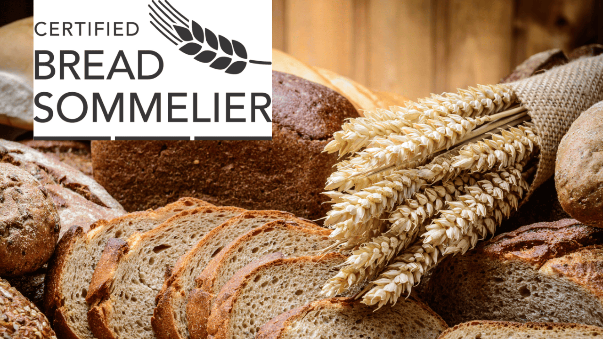 A variety of sliced and whole loaves of bread with stalks of wheat. In the top left corner, a logo reads Certified Bread Sommelier with an image of wheat.